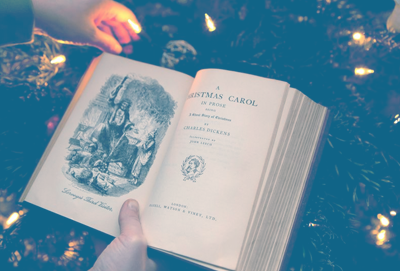 Two hands holding open a copy of A Christmas Carol to the title page