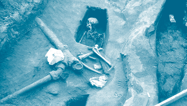 A Richard Barnes photo showing a partially excavated human skeleton under some plumbing