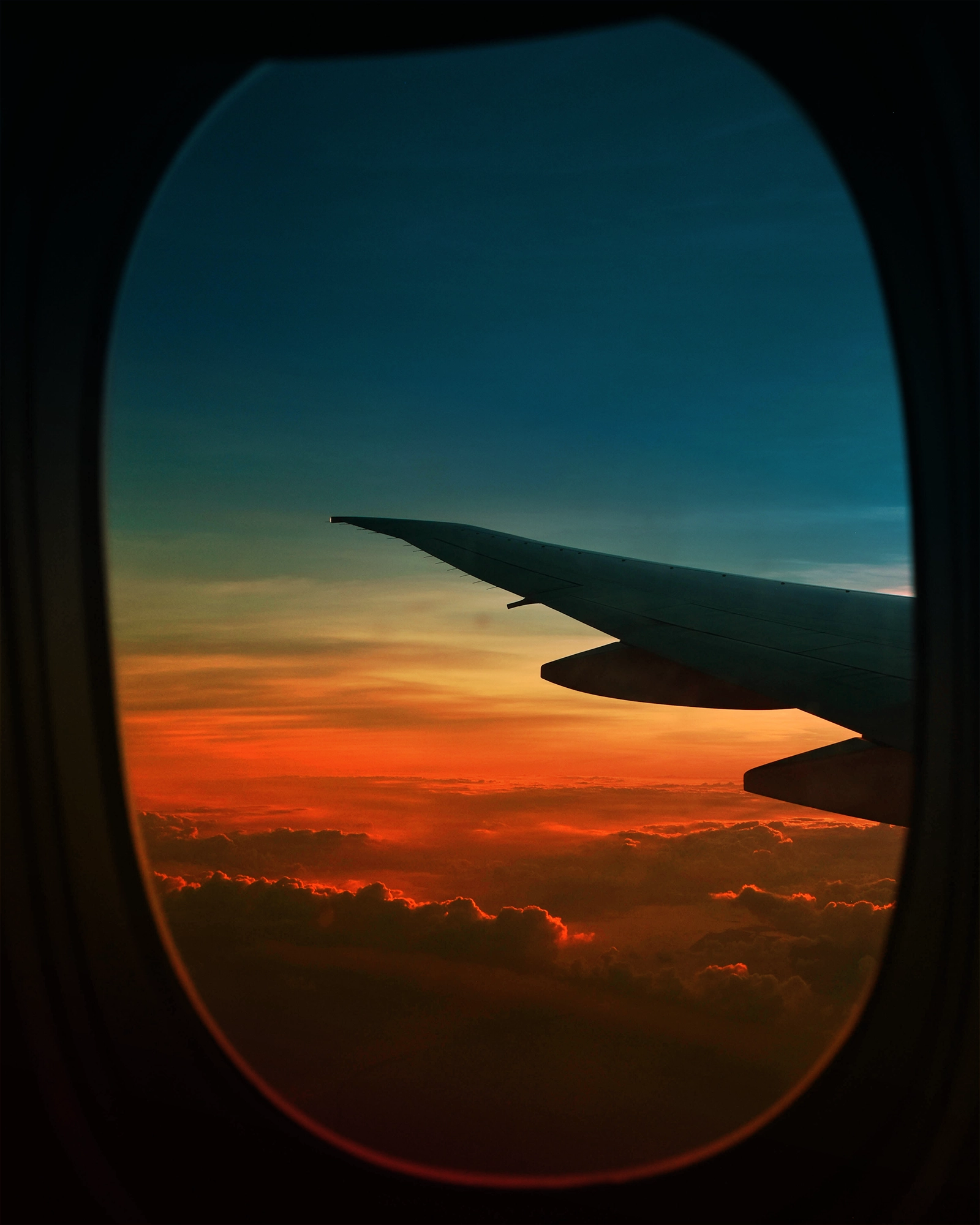The wing of a plane in flight, seen through a cabin window