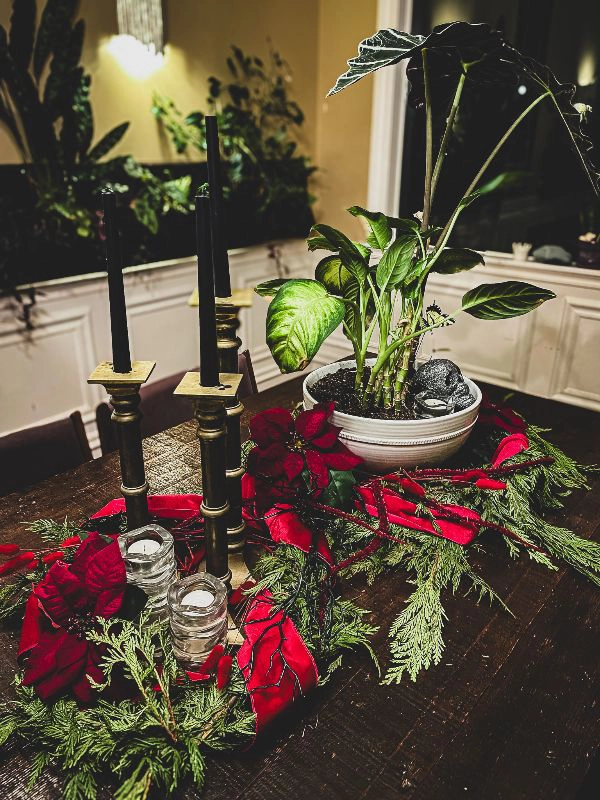 Evergreen centerpieces tied with dark red ribbon with poinsettias 