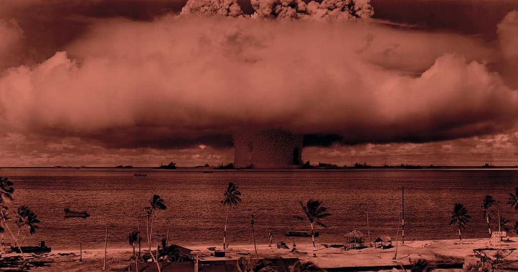 A color filtered image of the mushroom cloud blast in Bikini Atoll taken from the beach