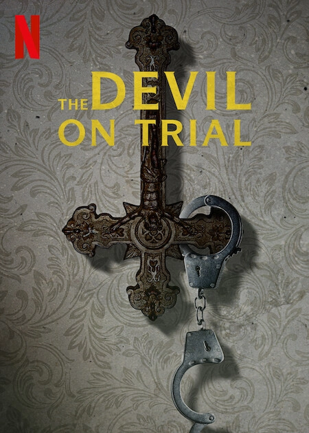 Promotional image from Netfilx for The Devil on Trial film, showing an inverted wooden cross on a wall with an open pair of handcuffs hanging off it