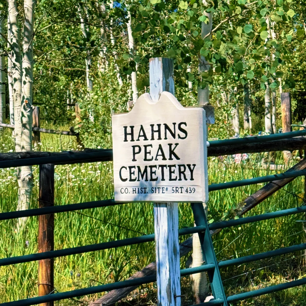 HLAS_SteamboatSprings_Graphics_4 A wooden sign on a signpost that reads "Hahn’s Peak Cemetery"